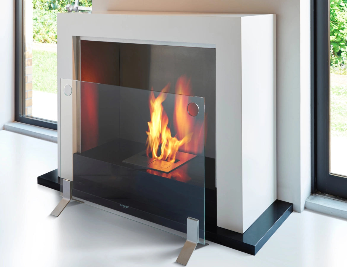 EcoSmart Fire Plasma Fire Screen with a clear glass panel and silver metal feet in front of a white fireplace.