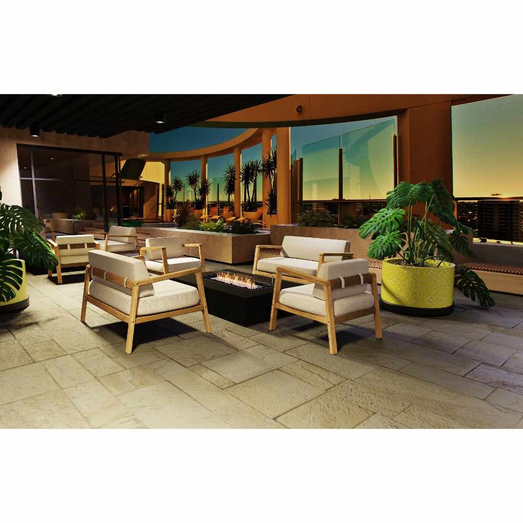 EcoSmart Fire Wharf 65 ethanol fire pit table in a black finish, centred among light wood armchairs on a stone patio.