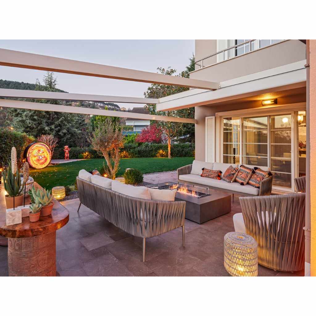 EcoSmart Fire Wharf 65 ethanol fire pit table with a grey concrete finish, centred in a modern outdoor patio lounge.