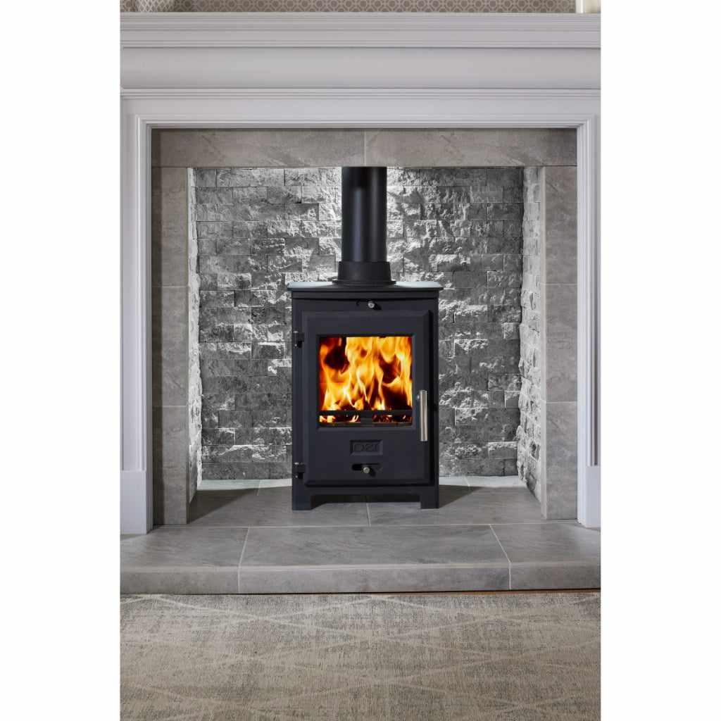 OER 5 MultiFuel 5KW stove in black with a lit fire, set in a grey stone fireplace surround and tiled hearth.