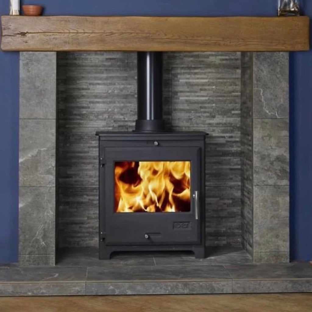 OER 8 MultiFuel 8KW wood burning stove in black, set in a grey slate tiled fireplace with a rustic oak mantel beam.