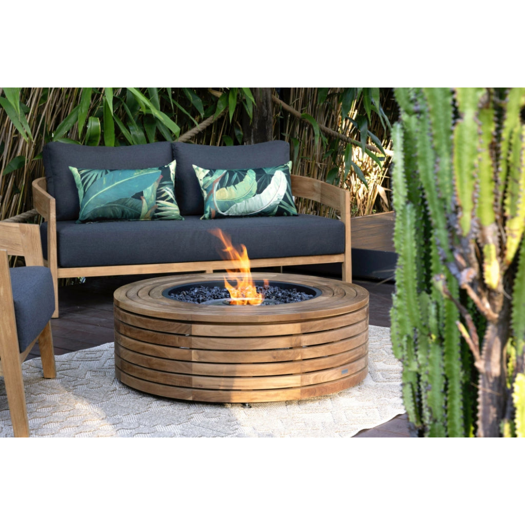 EcoSmart Fire Ark 40 bioethanol fire pit table with a slatted teak wood frame and central flame on a patio rug.