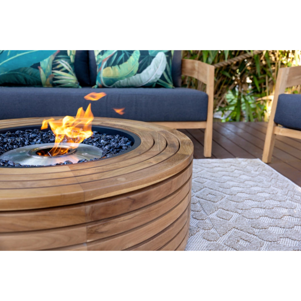 EcoSmart Fire Ark 40 round teak wood fire pit table with a central bioethanol flame and black glass fire media.