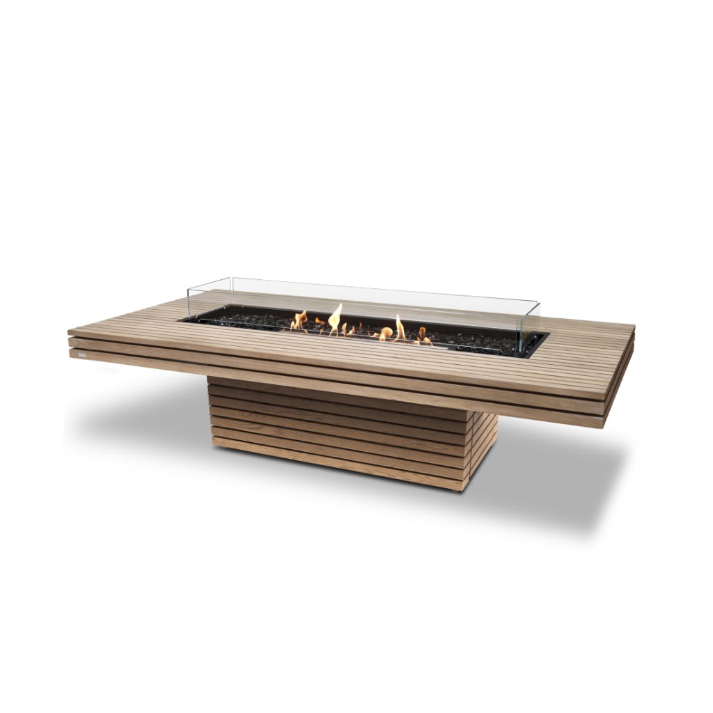 EcoSmart Fire Gin 90 bioethanol fire pit table in slatted teak wood with a central glass screen and black fire stones.