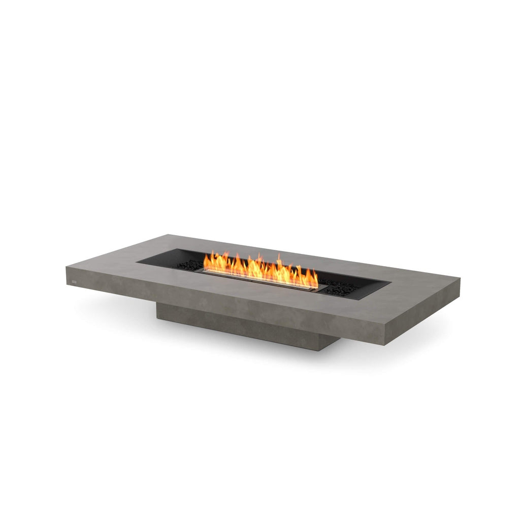 EcoSmart Fire Gin 90 low rectangular grey concrete fire pit table with a central linear flame and black decorative stones.
