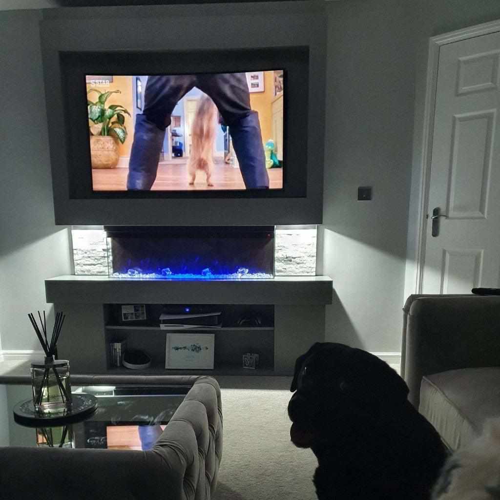 Emilia 72" grey media wall with a mounted TV, electric fireplace, stone-effect side panels, and integrated shelving.
