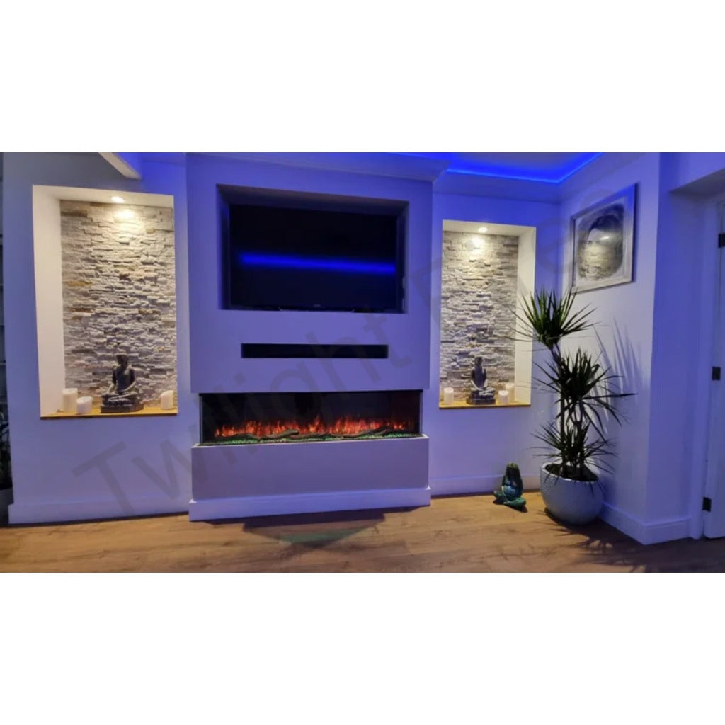 Luvelle 50” 3D panoramic electric fire with glowing orange flames, set in a white media wall with stone alcoves.
