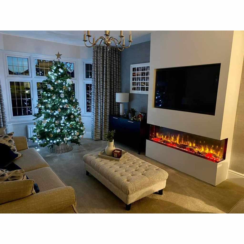 Luvelle 60” 3D panoramic electric fire with glowing flames, built into a white media wall below a wall-mounted TV.