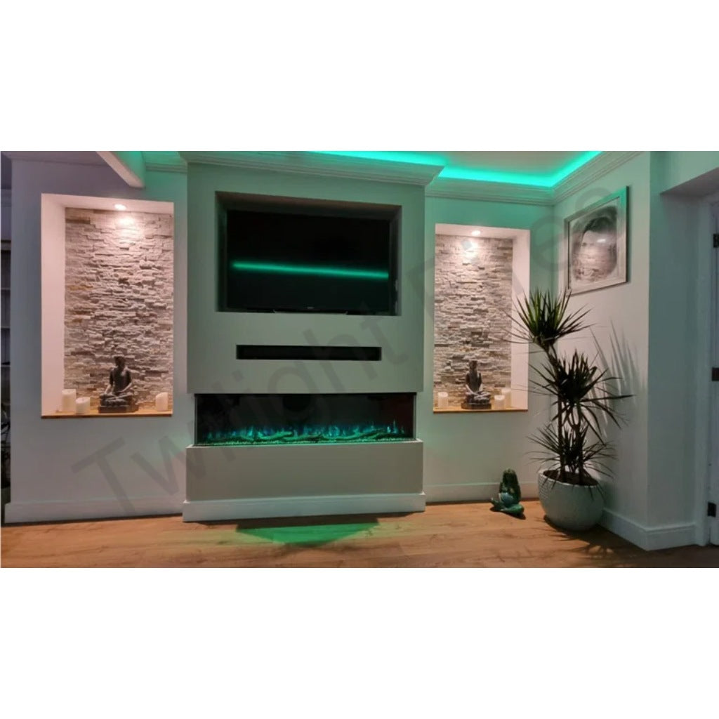 Luvelle 80” panoramic electric fire with blue flames, set in a white media wall with stone-effect alcoves and green lighting.