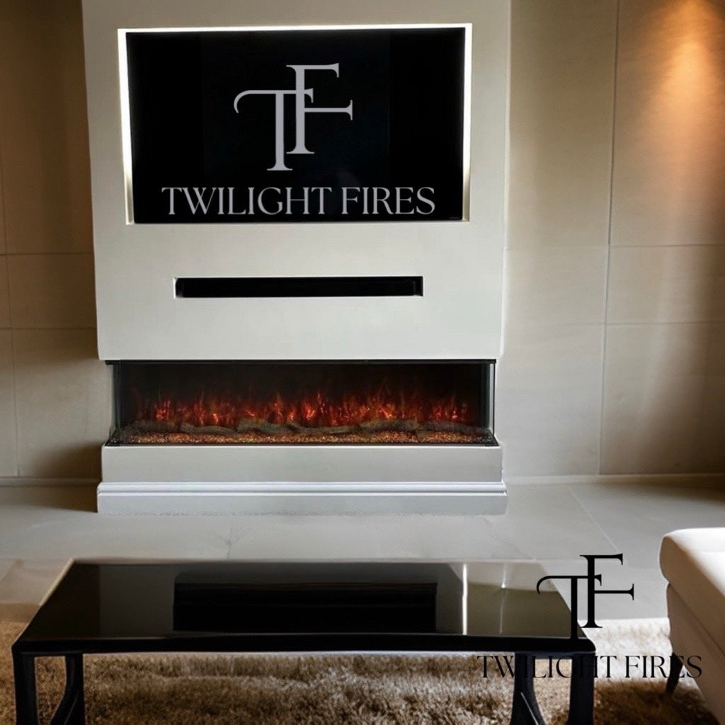 Slimline panoramic 3D electric fire with a three-sided glass display, glowing log fuel bed, set in a white media wall.