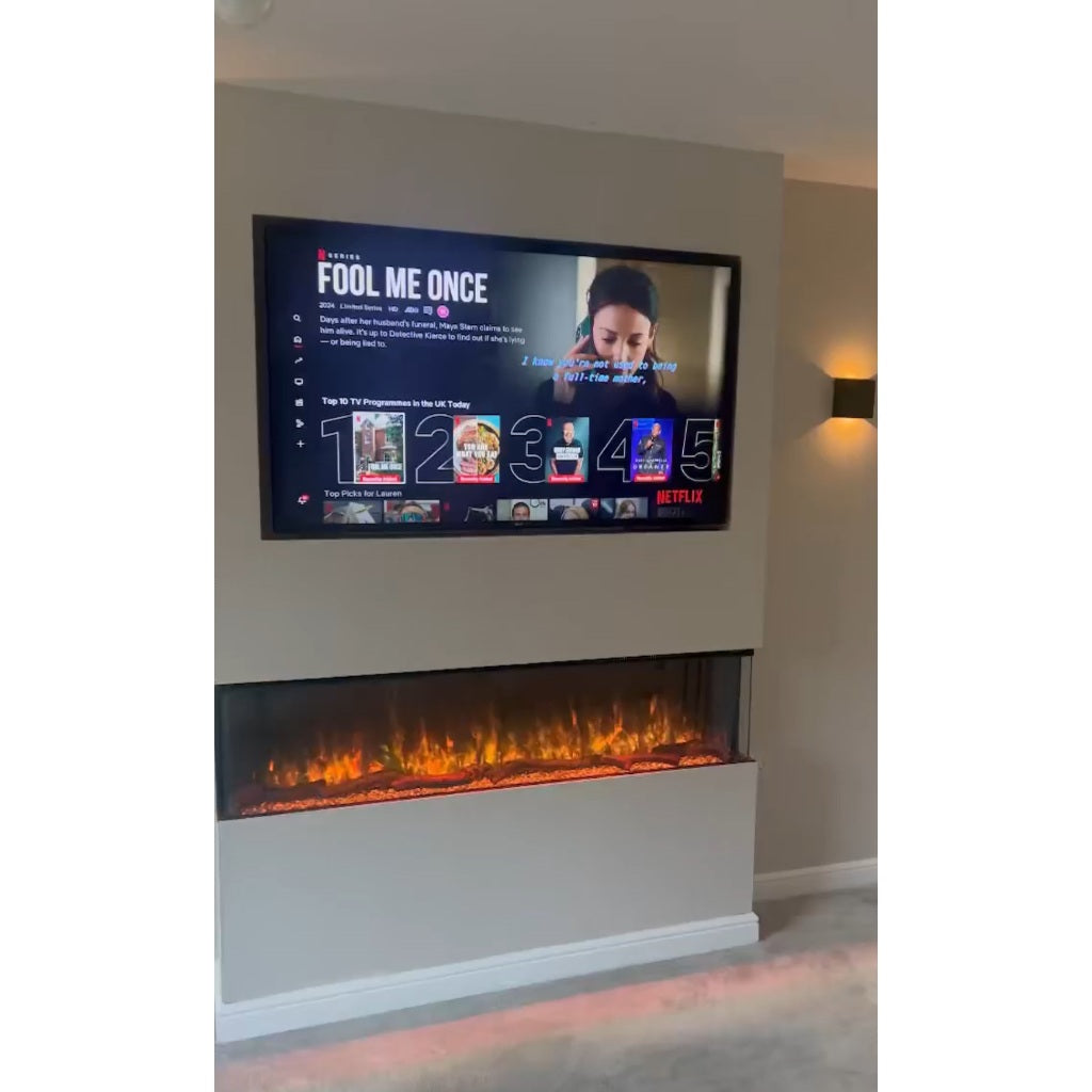 Slimline panoramic 3D electric fire with a three-sided glass display and glowing orange flames in a media wall.