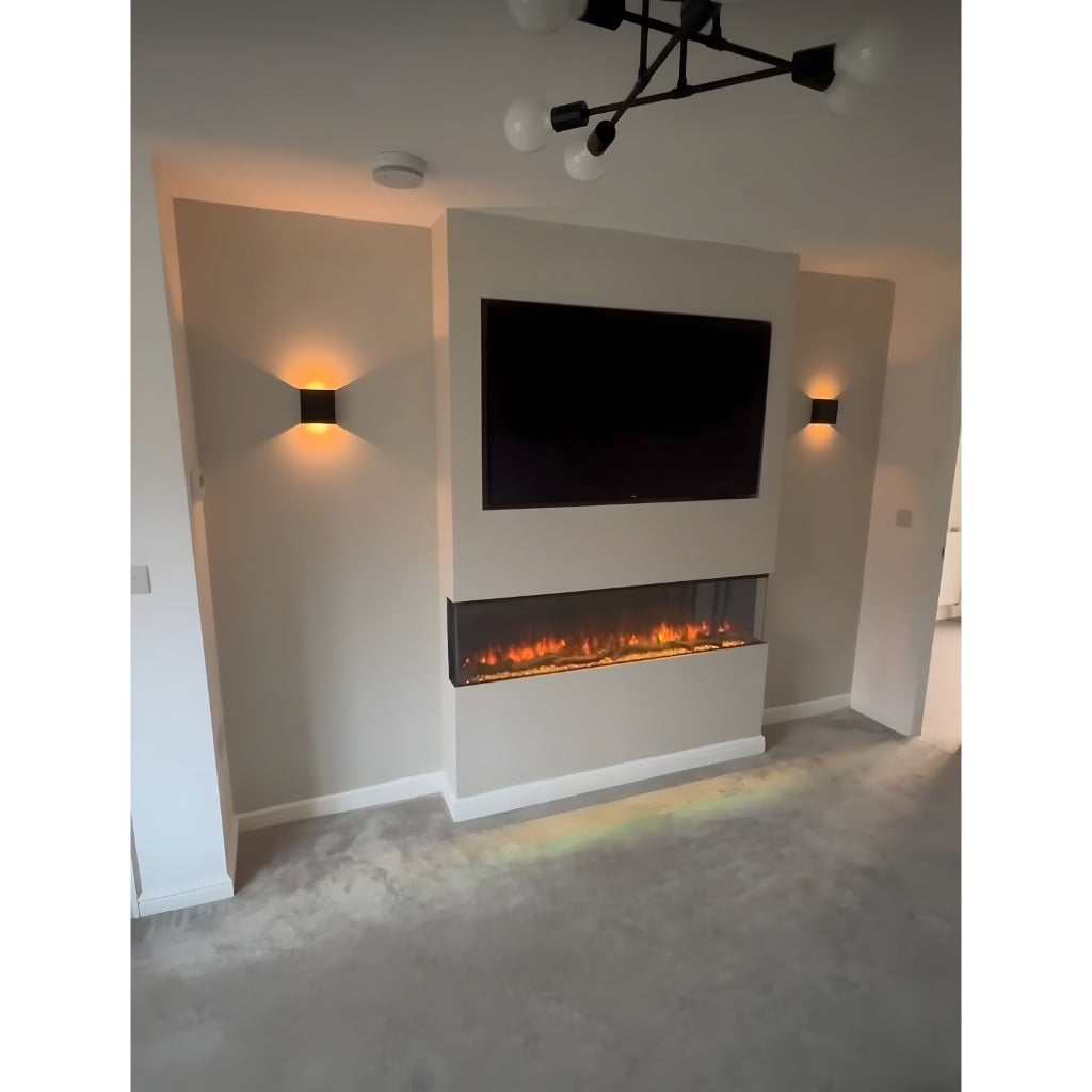 Slimline panoramic 3D electric fire with a three-sided glass display, set in a beige media wall below a mounted TV.