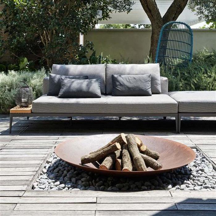 60cm Corten steel firepit bowl with a rustic rusted finish, filled with logs on a grey pebble patio.