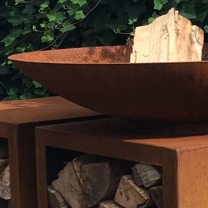 60cm Corten steel firepit bowl with a rusted finish, resting on a matching square base filled with logs.
