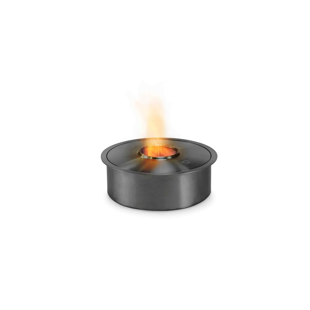 EcoSmart Fire AB3 ethanol burner in a circular, brushed stainless steel finish with a small orange flame lit.