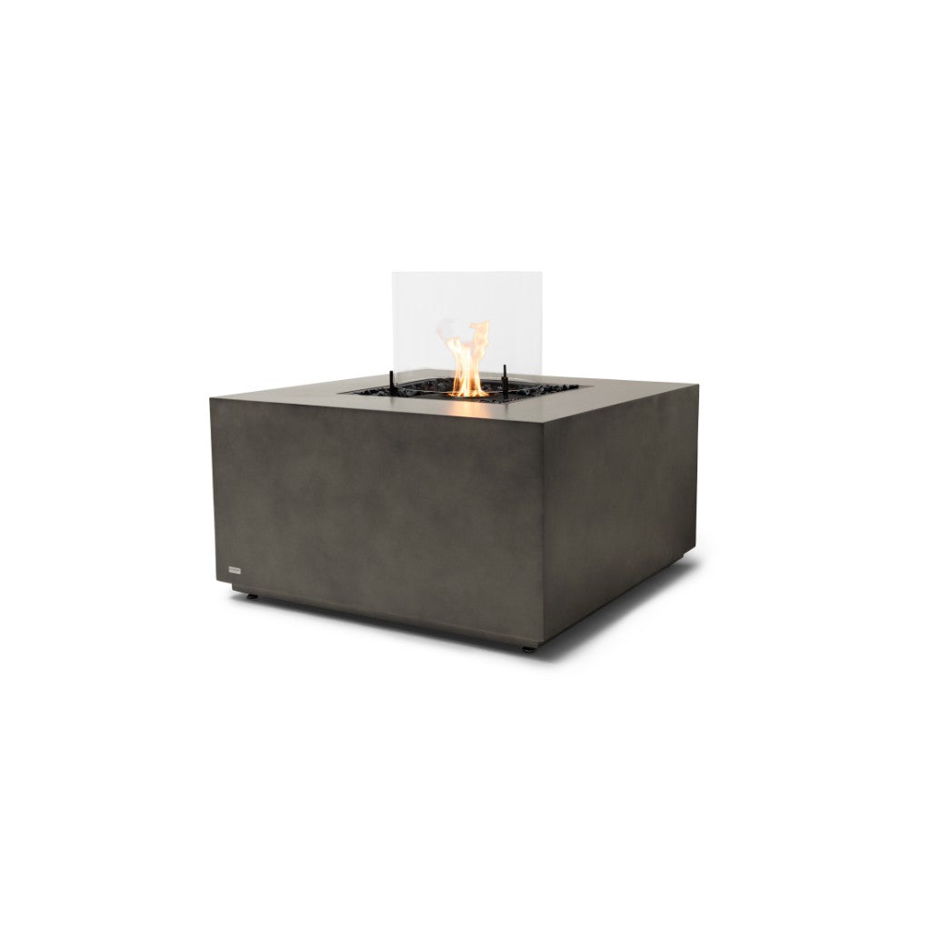 EcoSmart Fire Chaser 38 square grey concrete fire pit table with a central flame and glass wind screen.