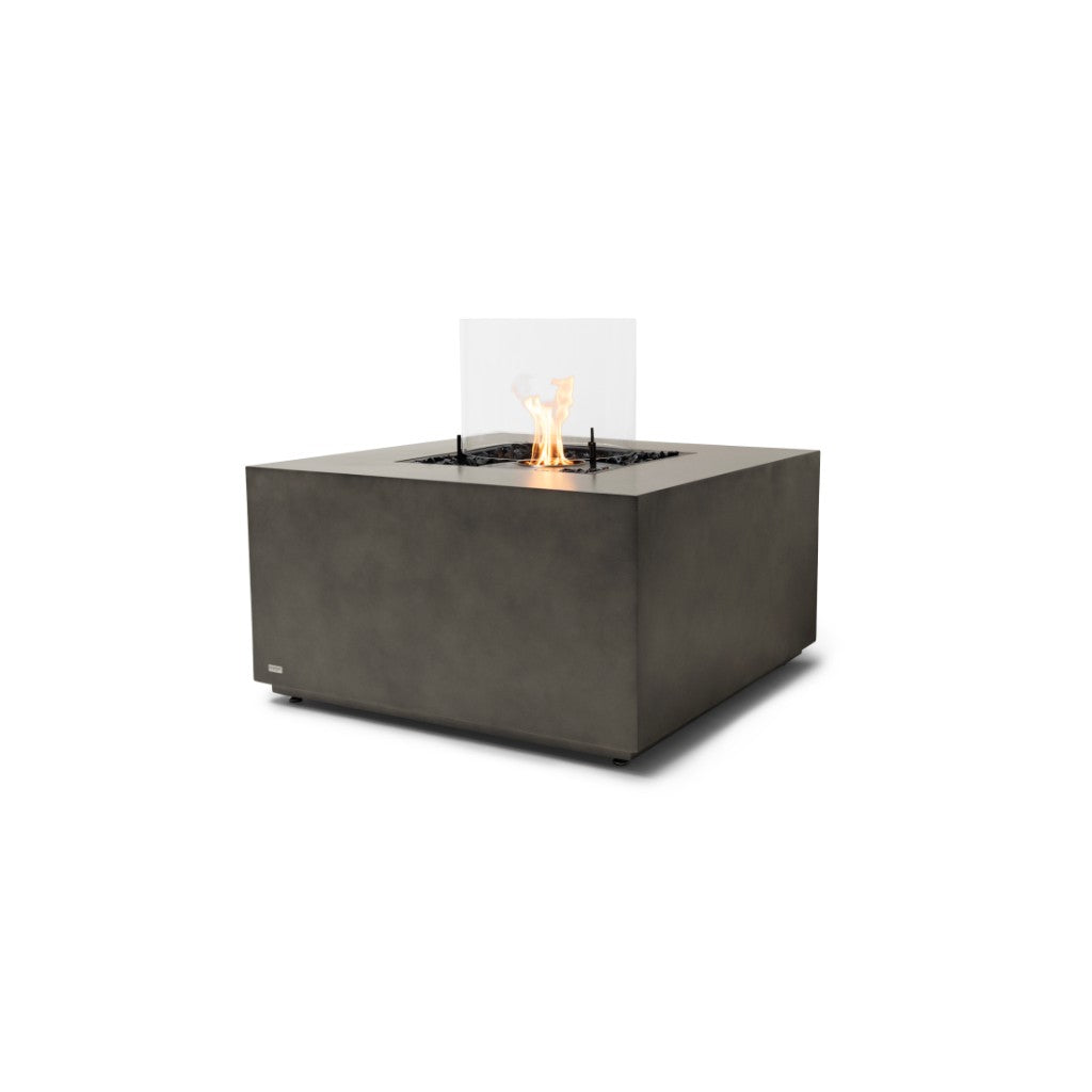 EcoSmart Fire Chaser 38 bioethanol fire pit table in grey concrete with a central flame and glass wind guard.
