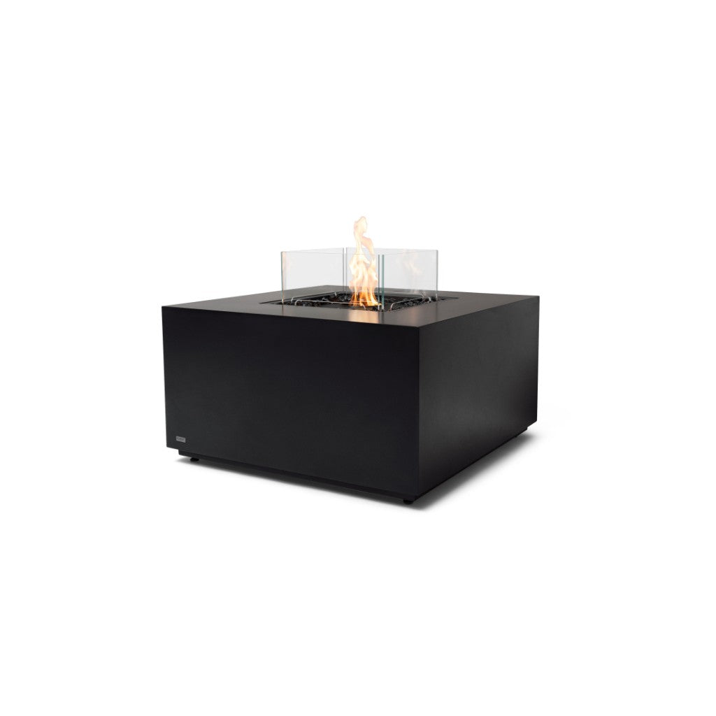 EcoSmart Fire Chaser 38 bioethanol fire pit table in matte black with a central flame and glass wind guard.
