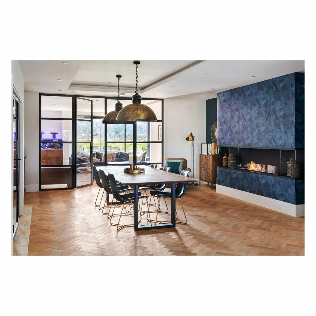 EcoSmart Fire Flex 104 installed in a blue marble-effect wall within a modern dining room with herringbone wood flooring.