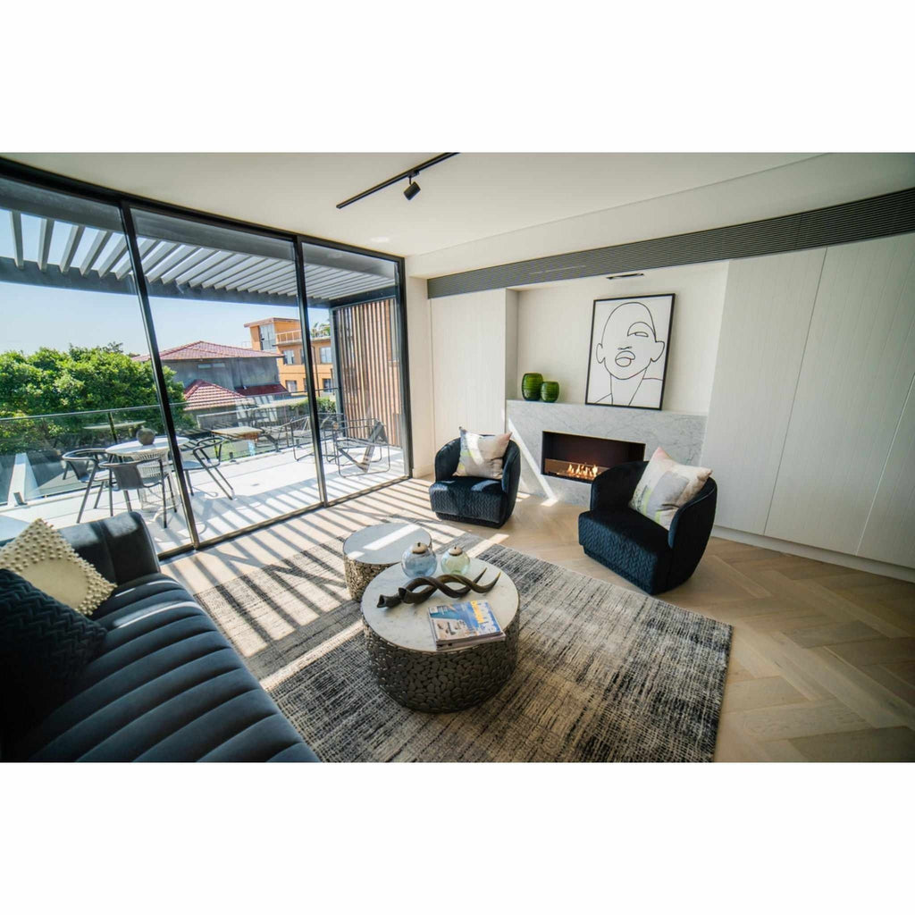 EcoSmart Fire Flex 42 bioethanol fireplace insert set in a white marble wall within a modern, open-plan living room.