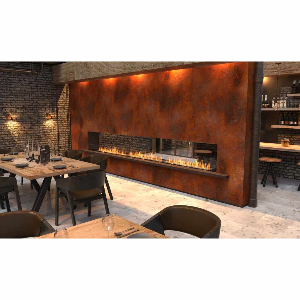 EcoSmart Fire Flex 50 bioethanol fireplace insert set into a rustic, weathered metal wall in a dining room.