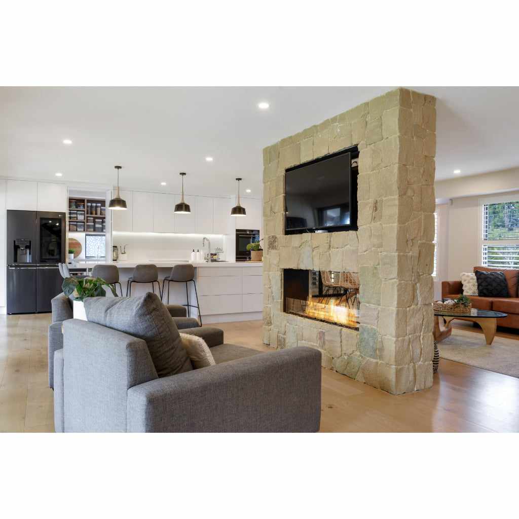 EcoSmart Fire Flex 50 bioethanol fireplace insert set into a rustic stone pillar dividing a modern open-plan room.