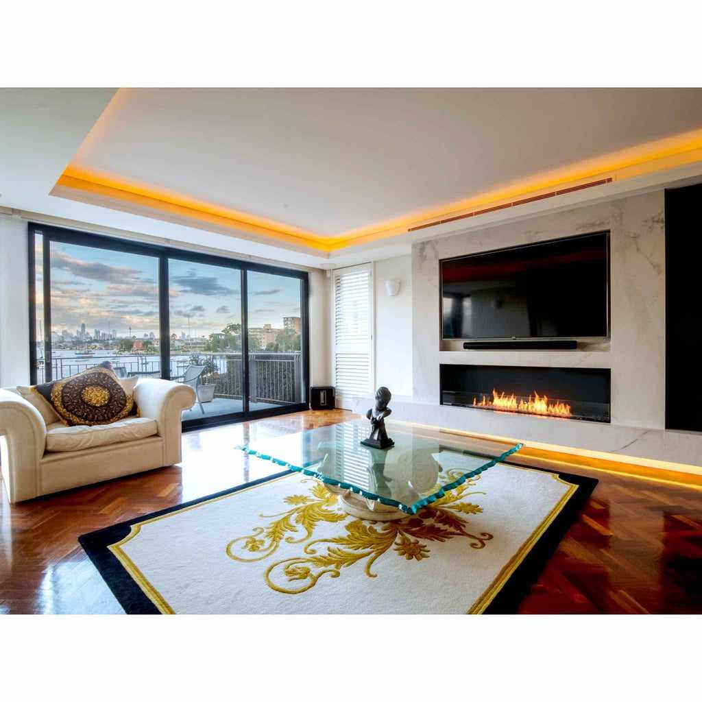 EcoSmart Fire Flex 78 fireplace insert with a long, linear flame set into a white marble wall below a television.
