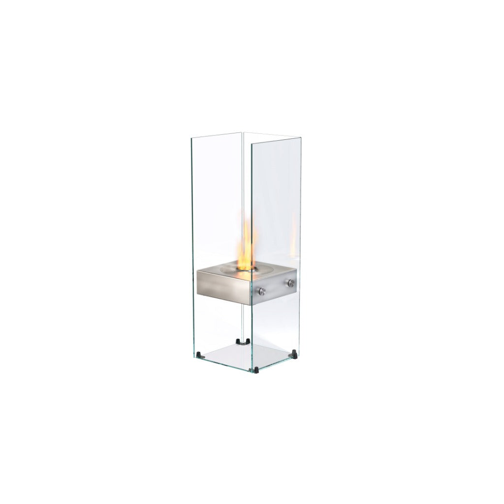 EcoSmart Fire Ghost bioethanol fireplace with a stainless steel burner inside a tall, clear glass enclosure.