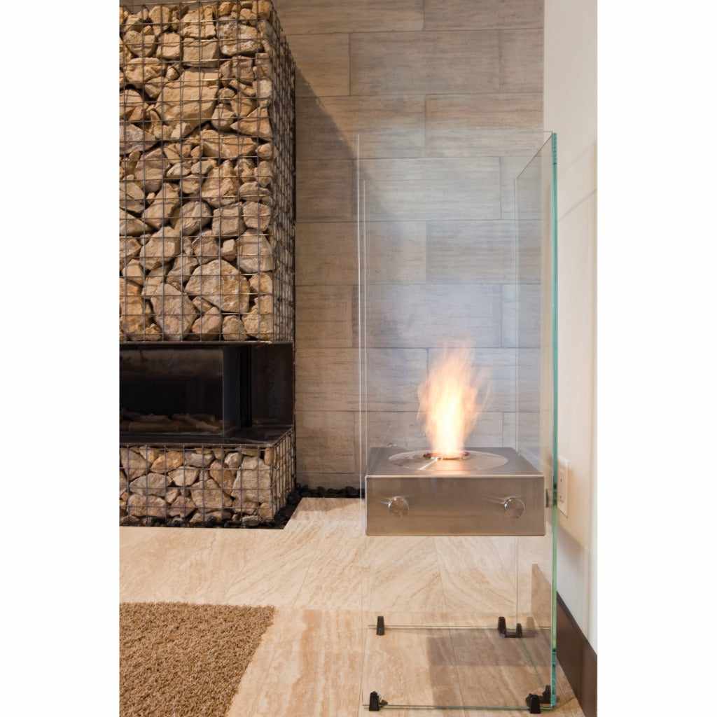 EcoSmart Fire Ghost bioethanol fireplace with a stainless steel burner and clear glass surround in a modern room.