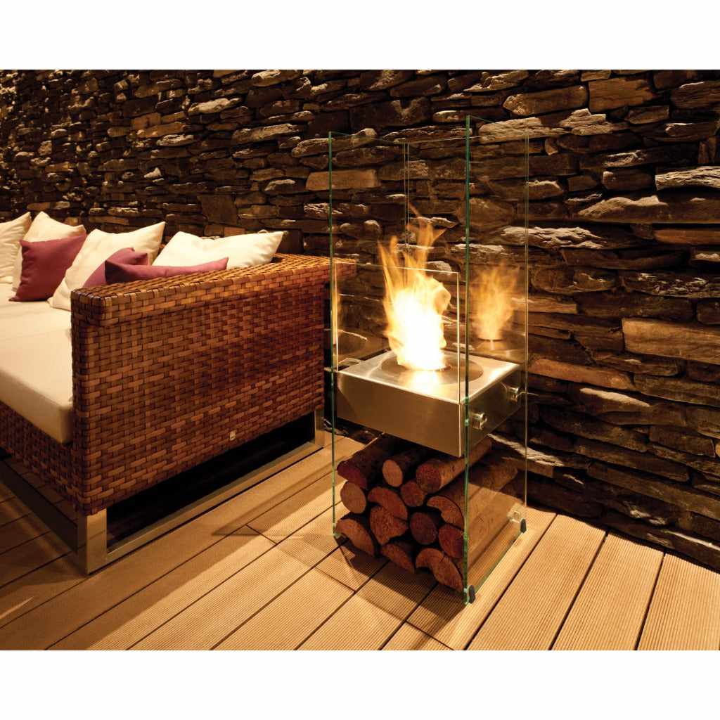 EcoSmart Fire Ghost bioethanol fireplace with a glass frame, stainless steel burner, and log storage on a deck.