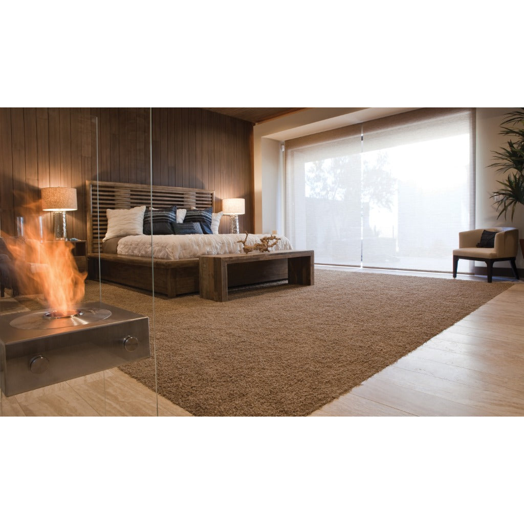 EcoSmart Fire Ghost bioethanol fireplace with a stainless steel finish and glass panels in a modern bedroom.