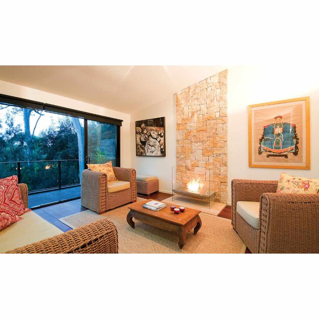 EcoSmart Fire Igloo bioethanol fireplace with a glass surround set against a textured stone feature wall in a lounge.