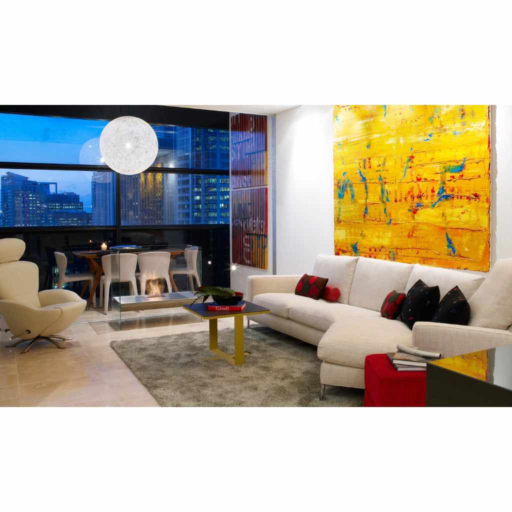 EcoSmart Fire Igloo bioethanol fireplace with a clear glass frame in a modern living room with city views.