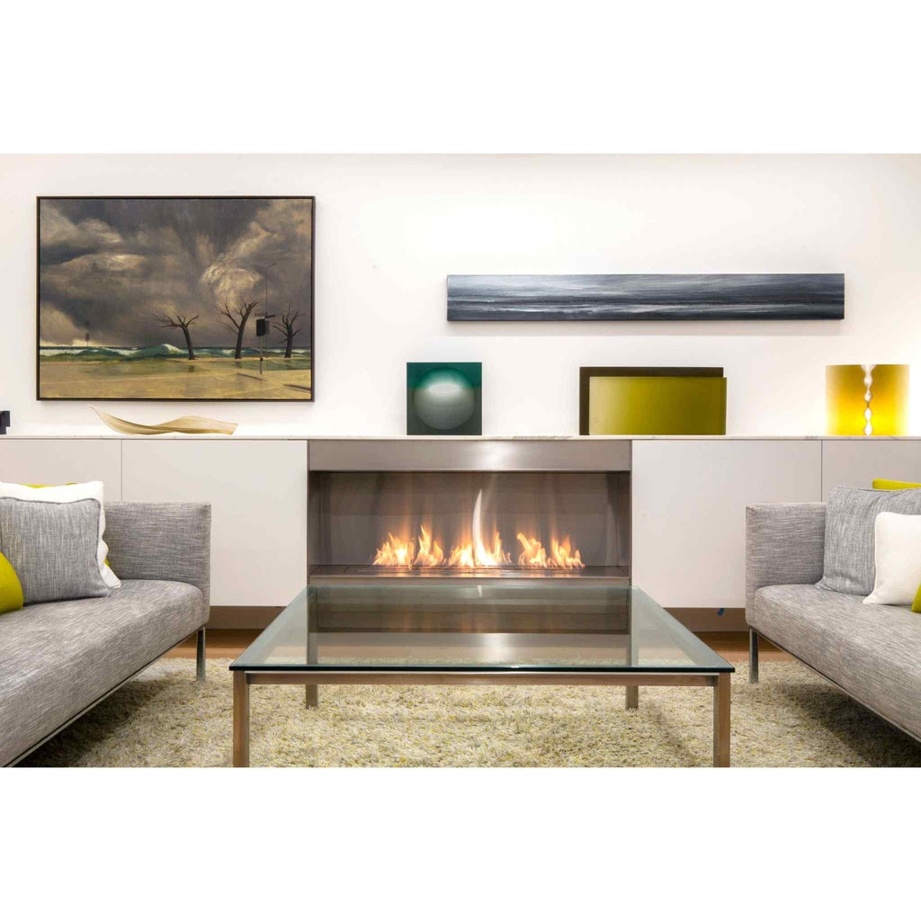 EcoSmart Fire XL1200 ethanol burner with a stainless steel finish, glowing flames, set in a modern living room.