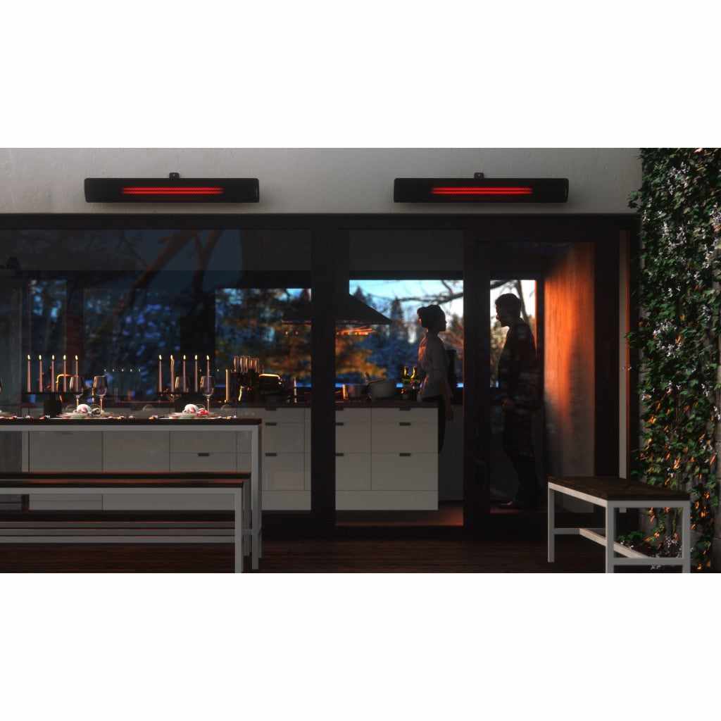 Two black Heatscope Heaters Pure 2400W mounted above a patio door, emitting a soft red glow at night.