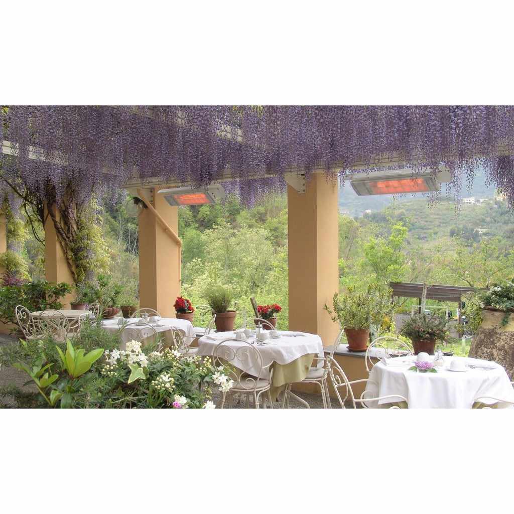 Heatscope Heaters Spot 2800W electric radiant heaters mounted on a terrace ceiling above outdoor dining tables.