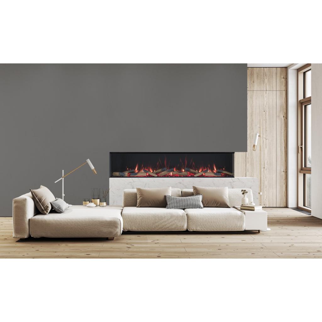 Vision Futura 72 inch 3-sided electric fire with realistic flames, set in a white marble surround above a beige sofa.