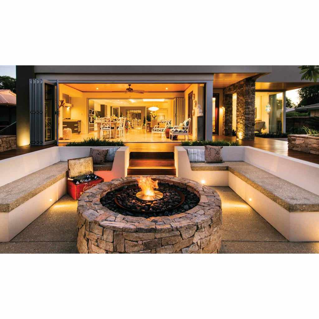 EcoSmart Fire AB8 Ethanol Burner with top tray set in a circular stone fire pit on a modern outdoor patio.