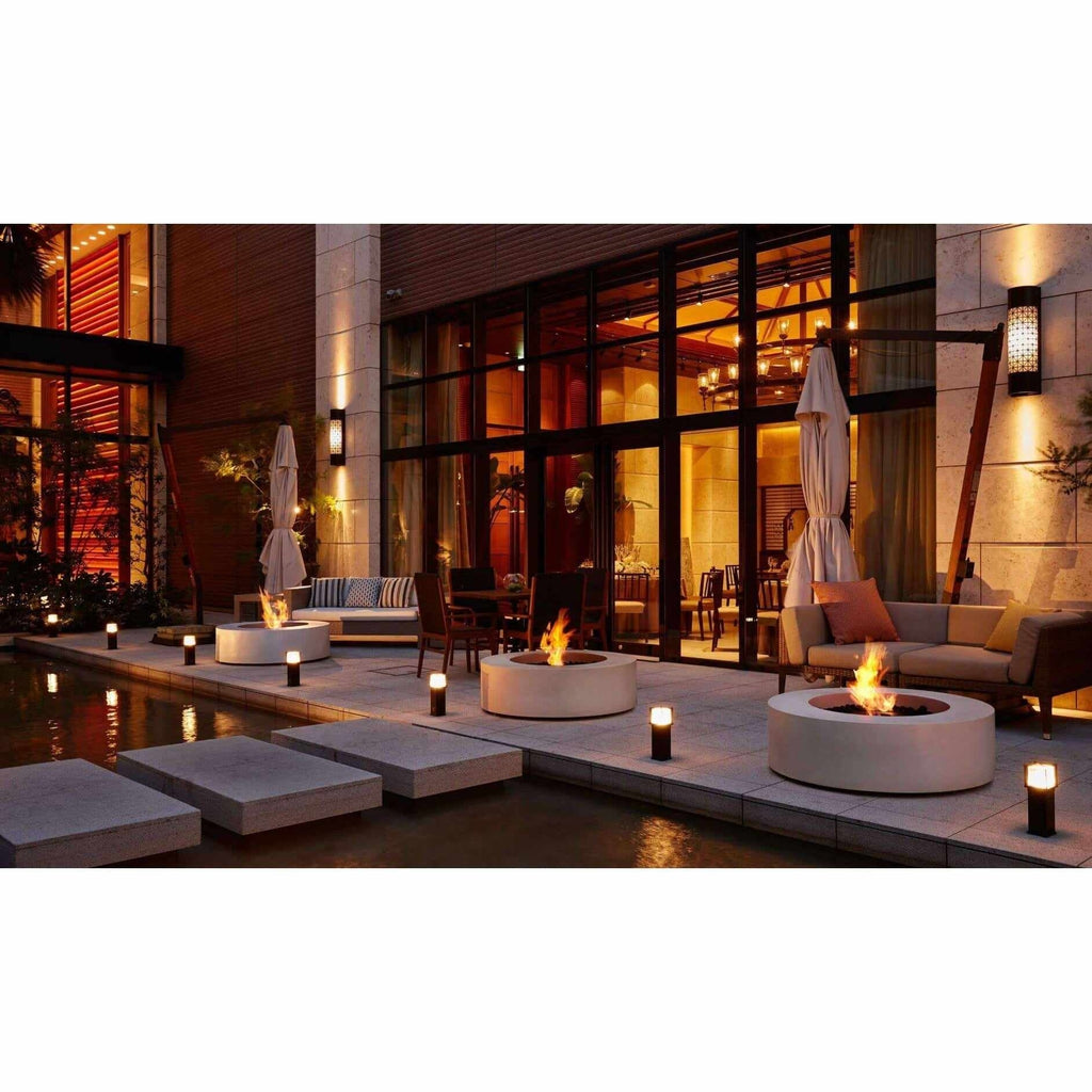 Three round, white EcoSmart Fire Ark 40 bioethanol fire pit tables with glowing flames on a modern patio.