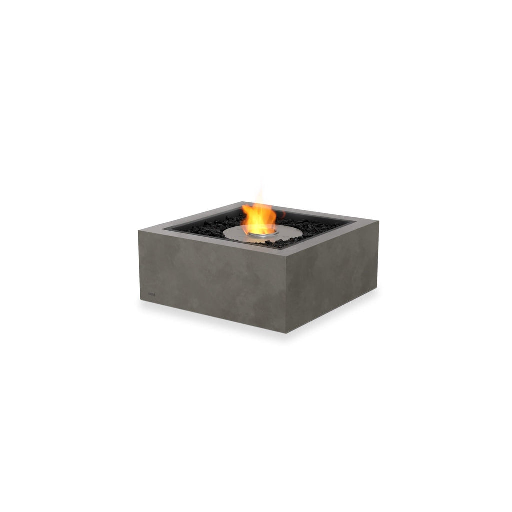 EcoSmart Fire Base 30 square grey concrete fire pit table with a central flame and black decorative stones.