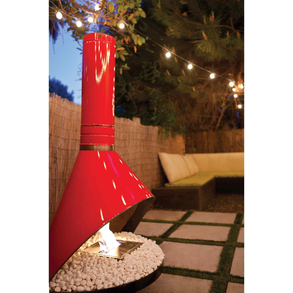 Bright red EcoSmart Fire BK5 ethanol burner with a conical chimney, set on a patio with white decorative stones.