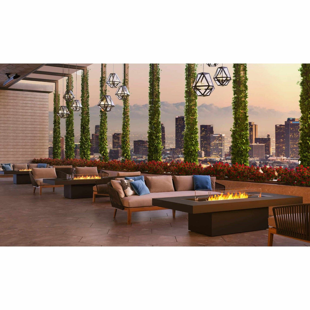 EcoSmart Fire Gin 90 bioethanol fire pit table with a black rectangular frame on a rooftop terrace at sunset.