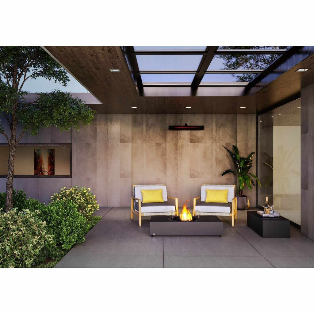 EcoSmart Fire Martini 50 bioethanol fire pit table in charcoal grey on a modern patio with two wooden armchairs.