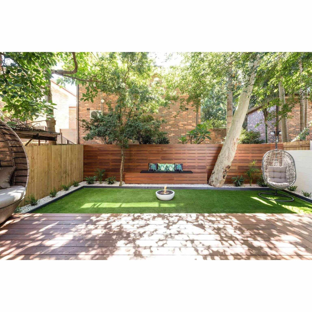 EcoSmart Fire Mix 600 bioethanol fire pit bowl in white, placed on a green lawn in a modern garden setting.