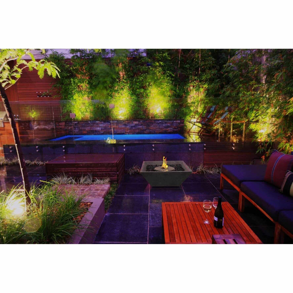 EcoSmart Fire Nova 600 bioethanol fire pit bowl in grey concrete on a dark tiled patio beside a swimming pool.