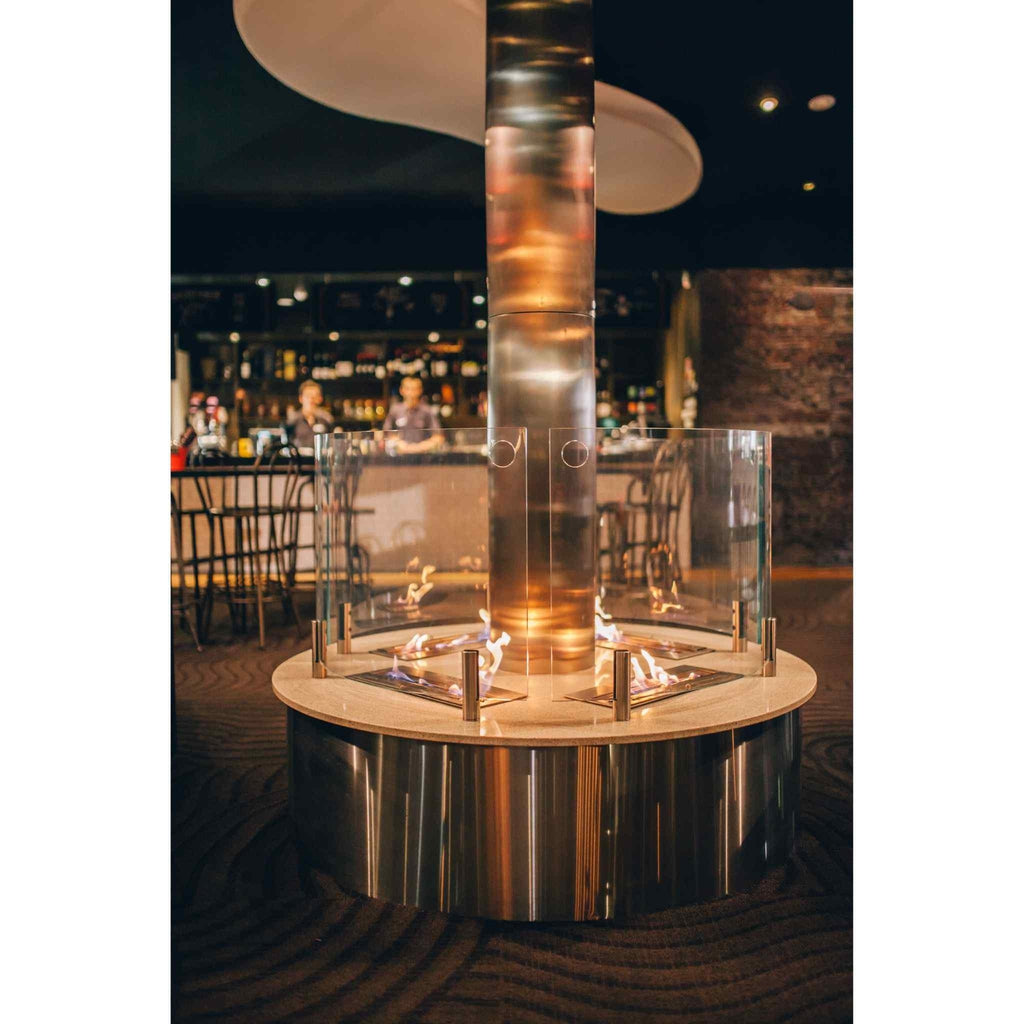 EcoSmart Fire XL500 ethanol burner integrated into a circular stainless steel base with glass guards and flames.