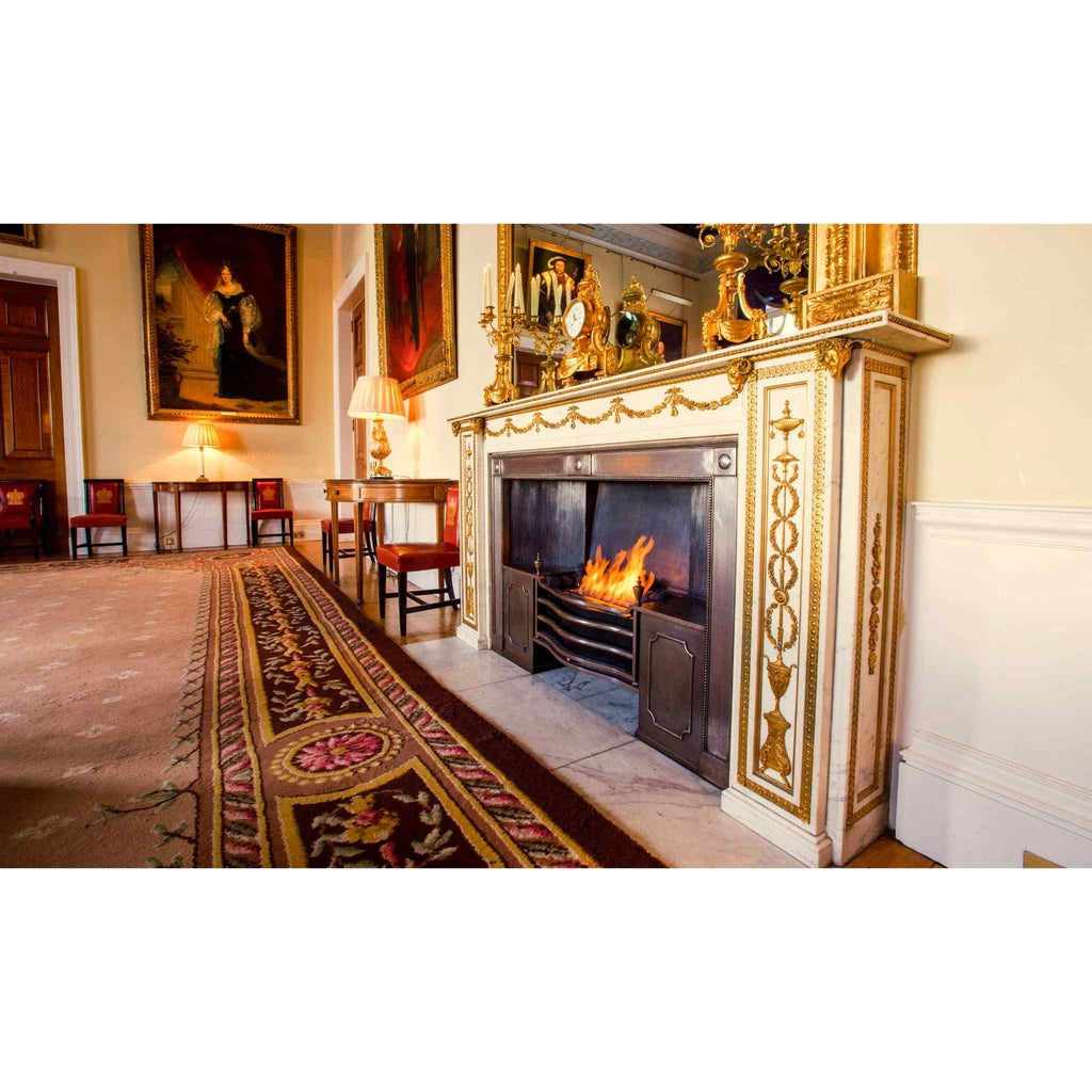 EcoSmart Fire XL500 ethanol burner installed in a traditional fireplace with a decorative gold-trimmed mantelpiece.