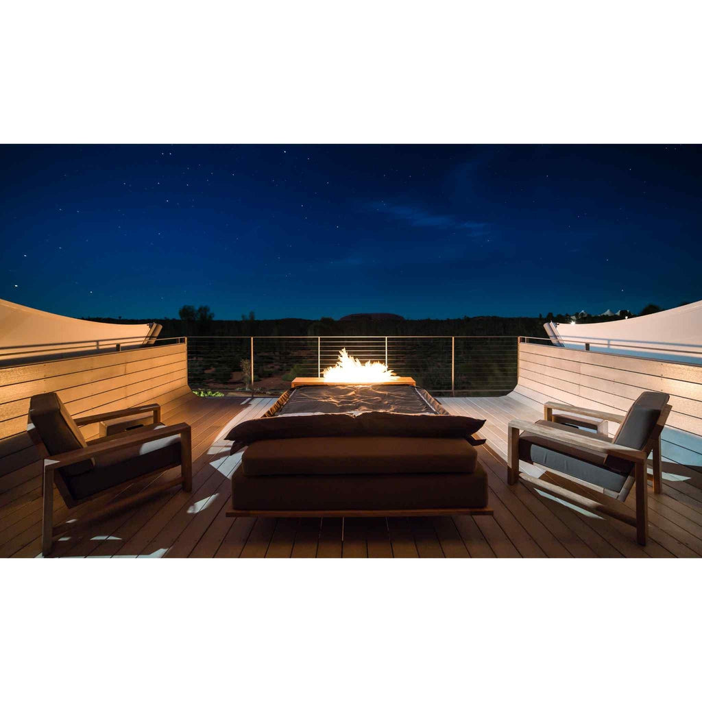 EcoSmart Fire XL700 ethanol burner glowing on a wooden deck with two armchairs under a night sky.
