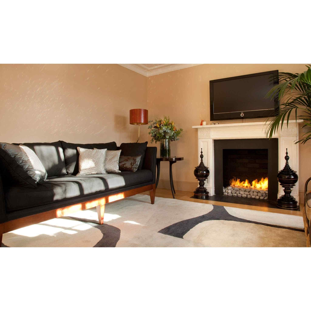 EcoSmart Fire XL700 ethanol burner with glowing flames and decorative stones inside a white fireplace mantel.