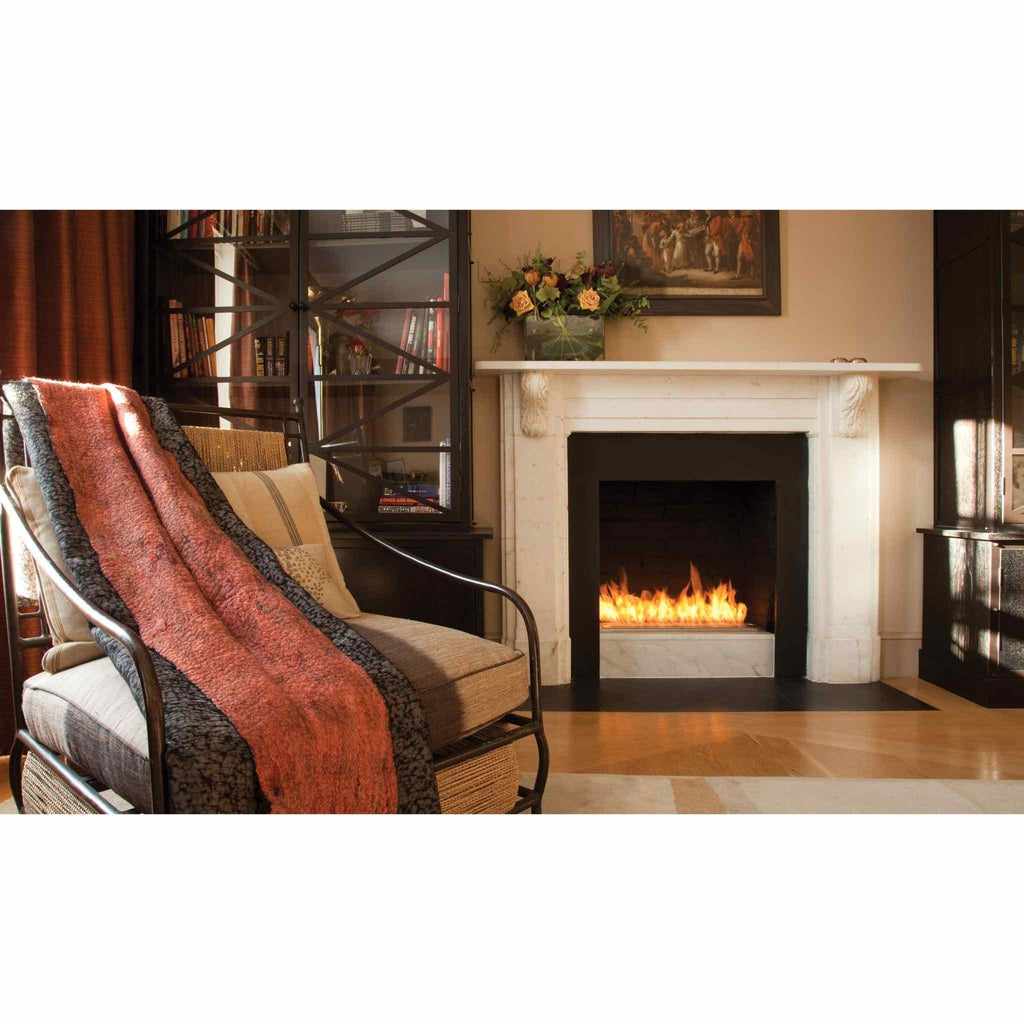 EcoSmart Fire XL700 ethanol burner with a linear orange flame set inside a white marble fireplace mantel.